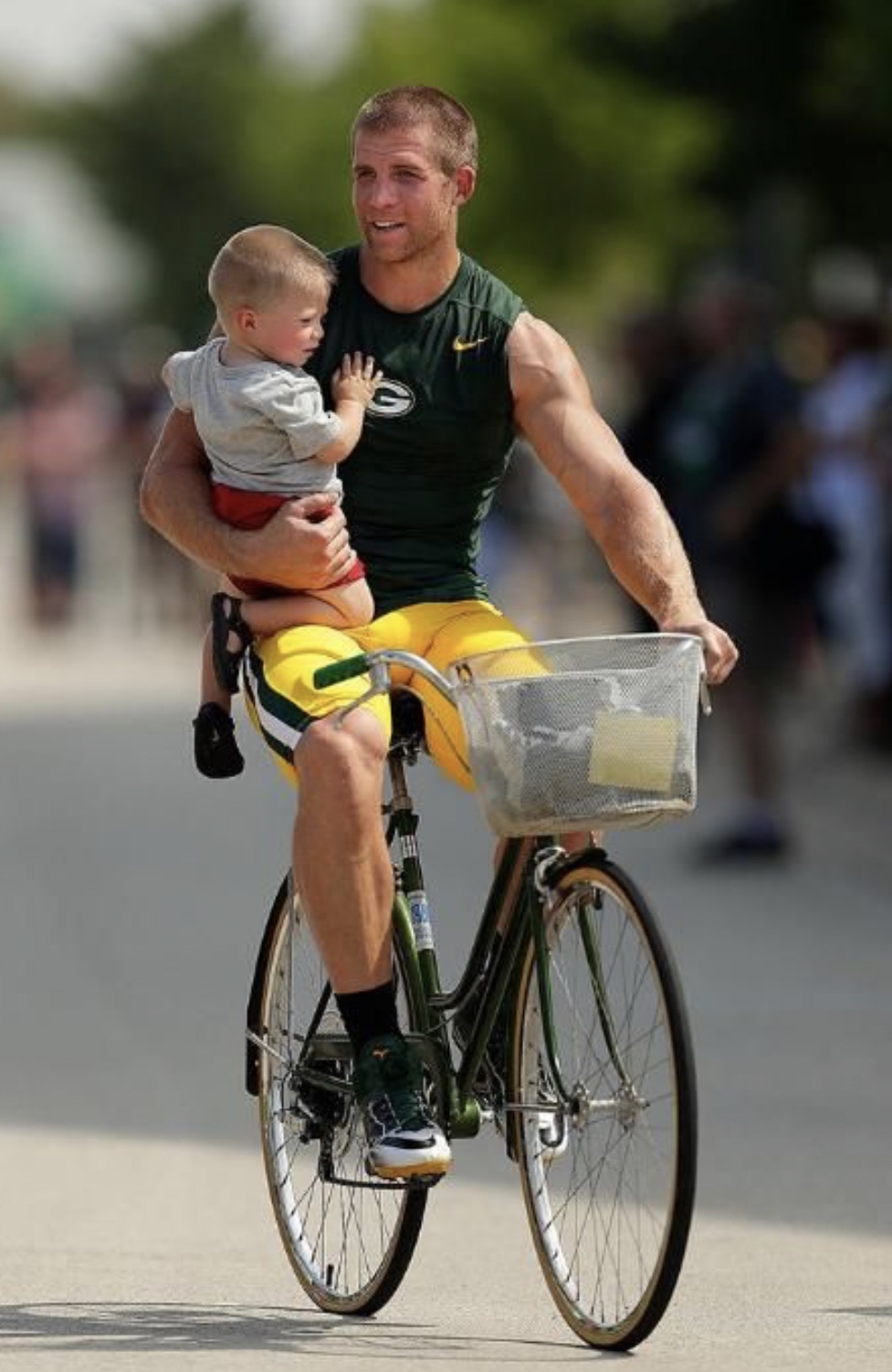 Jordy Nelson rides his bike holding a baby so he has someone to blame for those pee drenched socks